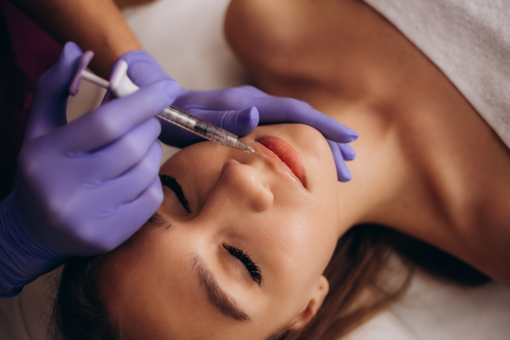 Botox Injection To Woman Lips Who Lies Relaxed With Her Eyes Closed
