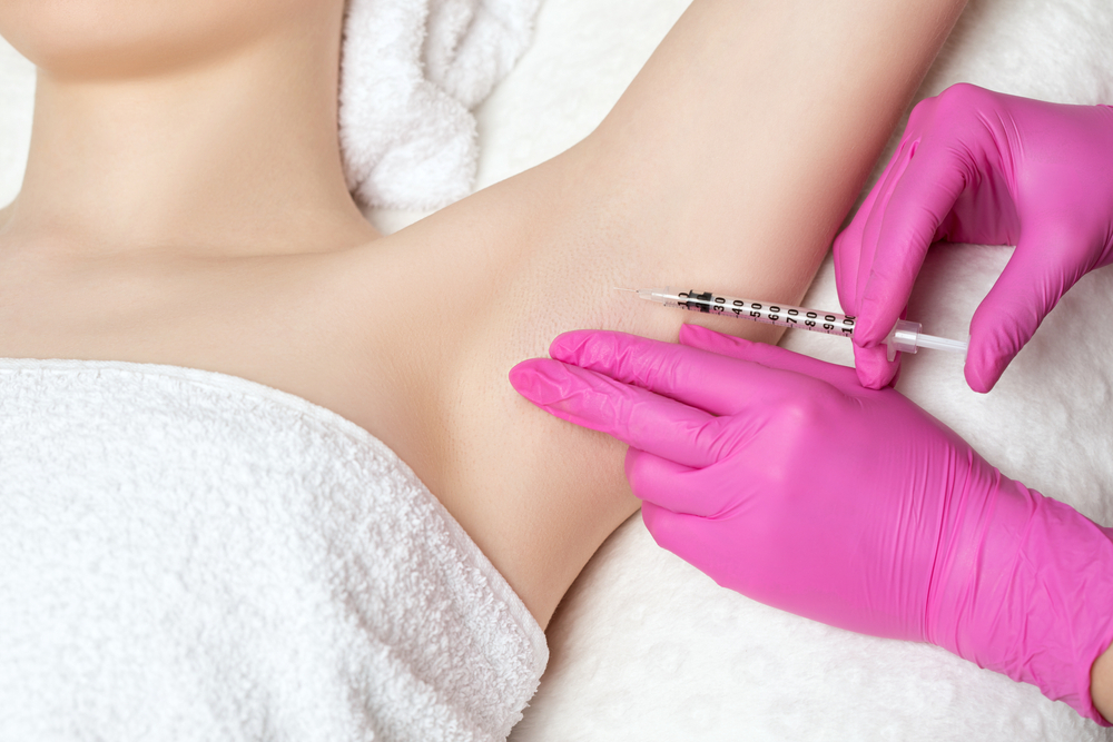 doctor injecting botox for under arms to female patient