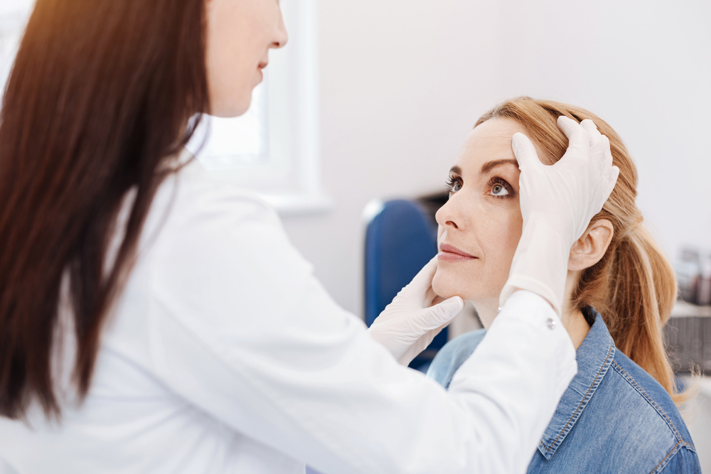 Dermatologist Examining Female Patient Before Morpheus8 Treatment