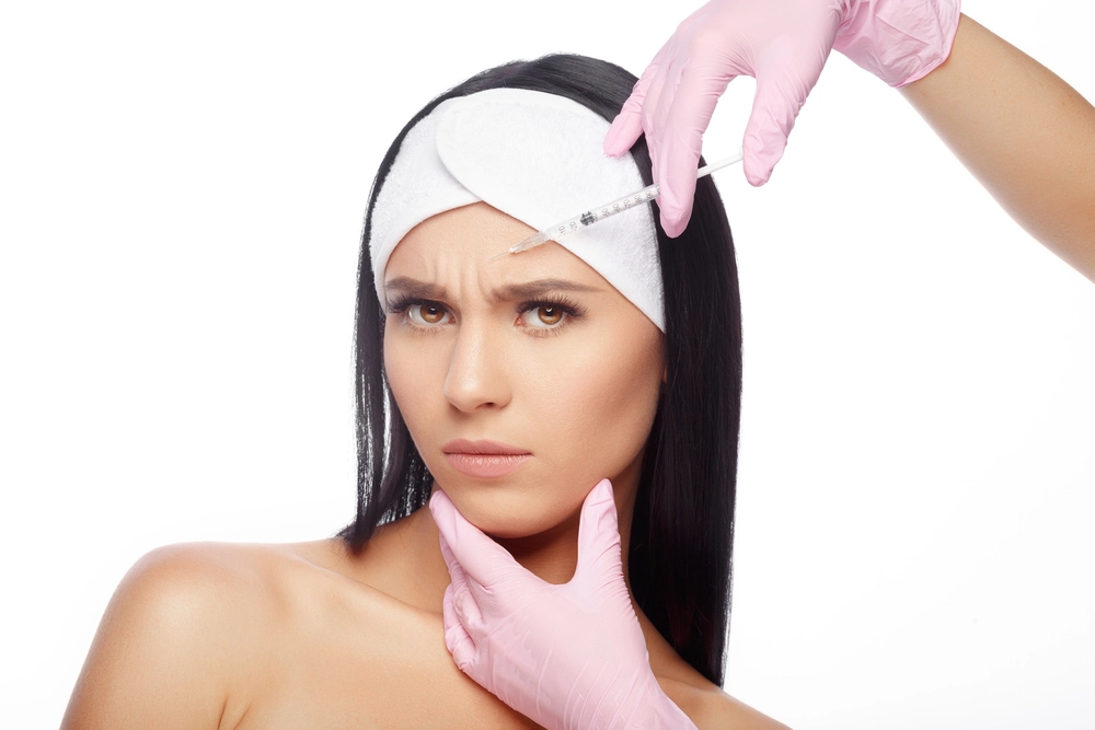 Woman receiving a XEOMIN® cosmetic injection to reduce facial wrinkles.