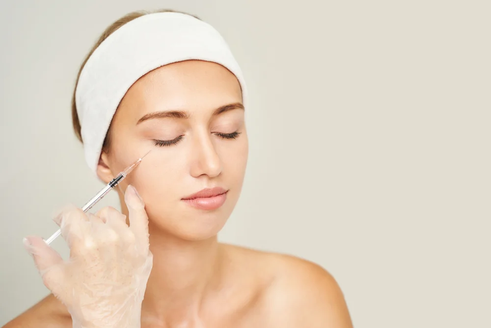 Close-Up Of A Serene Woman Receiving A Cosmetic Filler Injection To Enhance Facial Collagen Production, Promoting Skin Rejuvenation.
