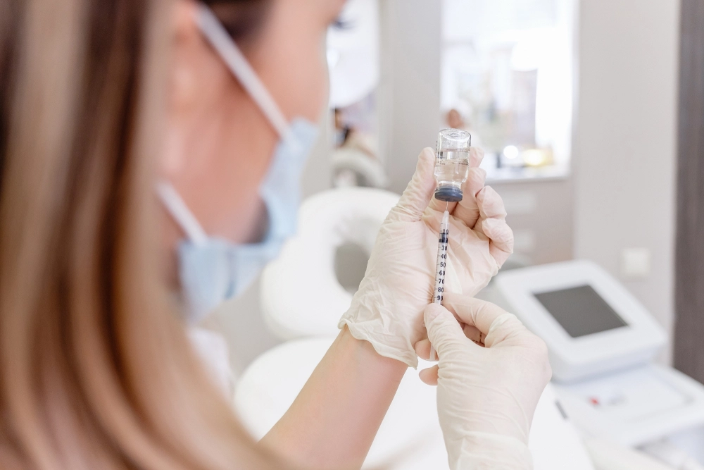 Healthcare professional preparing Xeomin injectable for cosmetic treatment in clinic setting.