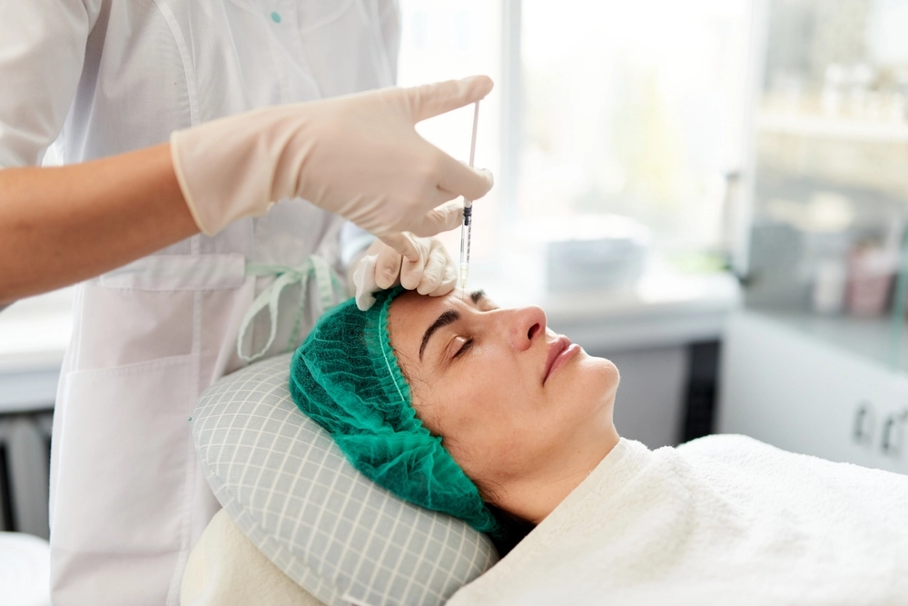 Patient receiving a Jeuveau injection for facial wrinkles by a professional in a clinical setting.