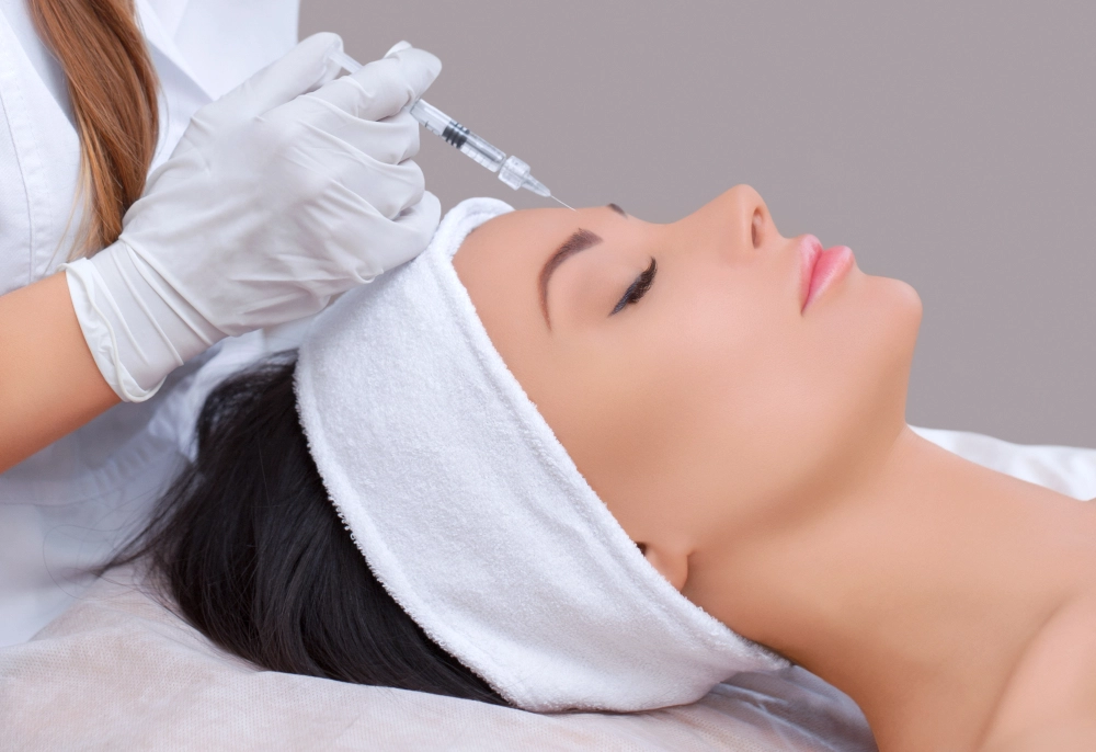 Patient receiving Xeomin cosmetic injection treatment for facial wrinkles by a professional in a medical spa.