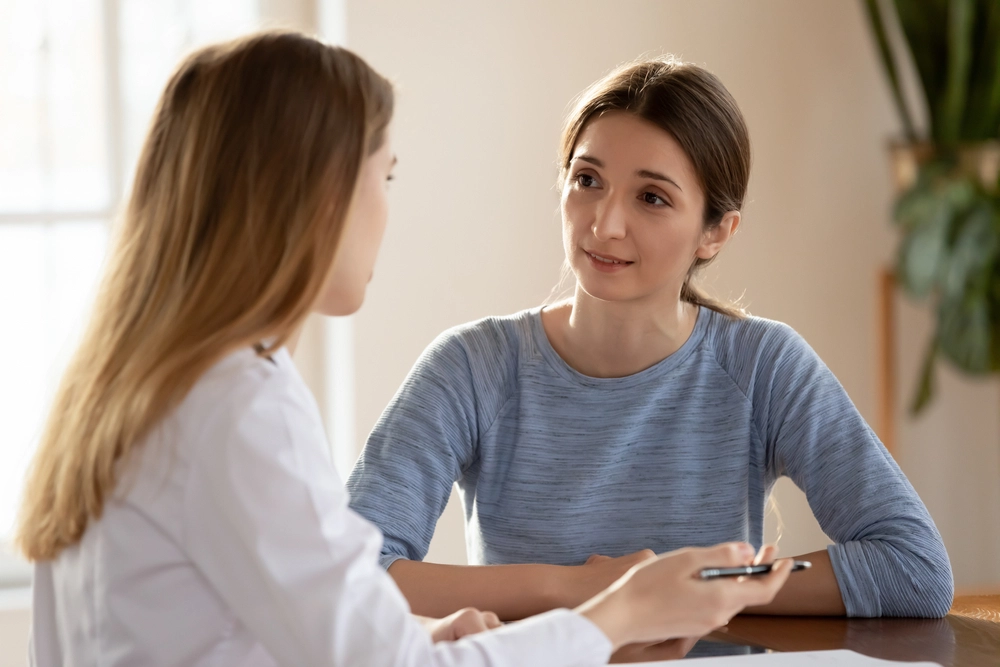 Cosmetologist Discussing Side Effects And Risks Of Restylane Eyelight Procedure With Patient.