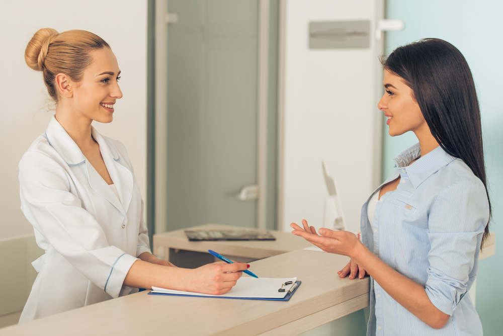 Cosmetologist Discussing Aftercare And Recovery With Patient In Clinic