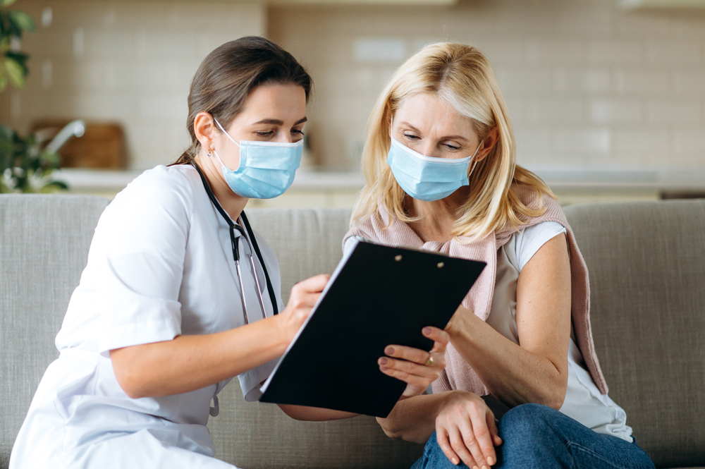 Doctor discussing potential side effects and risks of Botox treatment for migraines with a patient.