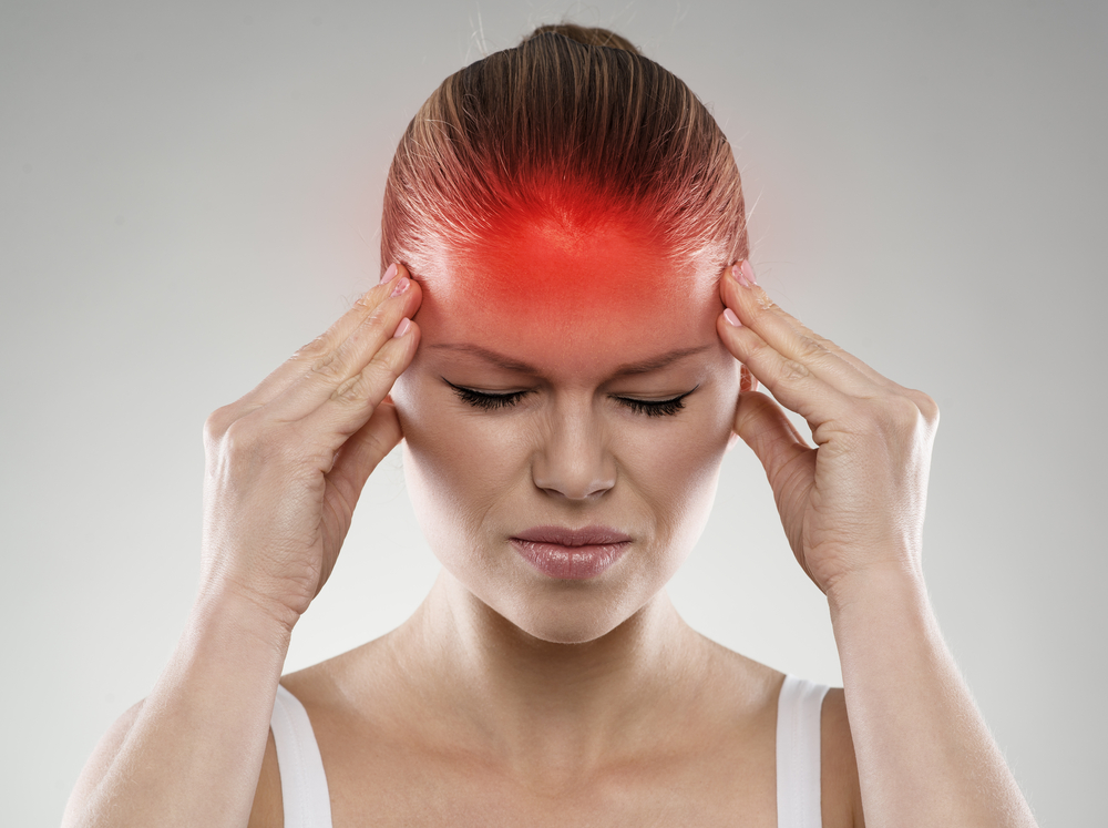 Woman experiencing migraine pain with red-highlighted forehead area, ideal for Botox treatment