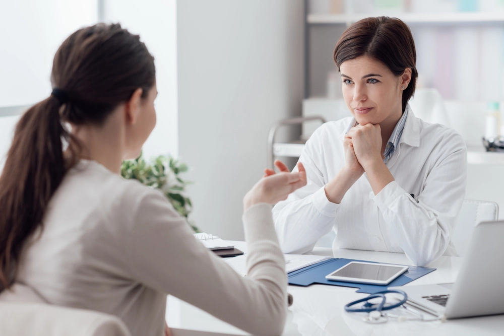 Cosmetologist discussing aftercare and recovery guidelines with a patient post Sculptra butt lift procedure.